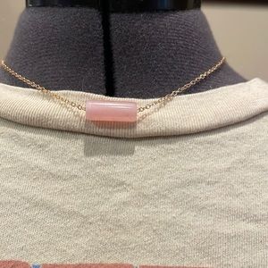 This is a pink crystal necklace with a gold chain
